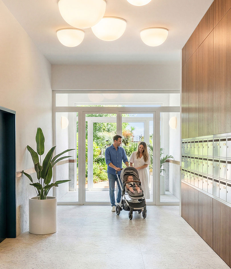 Un couple et un enfant dans un hall d'immeuble
